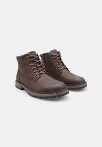 Stivaletti in pelle marrone con design a lacci, colletto imbottito, superficie testurizzata e suola in gomma robusta con grip per una buona aderenza.