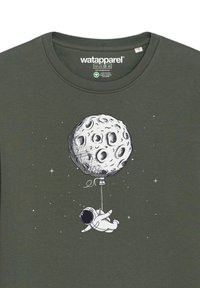 Olijfgroene katoenen t-shirt met een astronaut die onder een ballon in de vorm van de maan zweeft, geïllustreerd in zwart-wit.