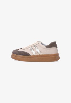 Beige Leder Sneaker im Low-Top-Stil, mit braunen Wildlederakzenten, metallisch silbernen Streifen, weißen Schnürsenkeln und einer dicken braunen Gummisohle.