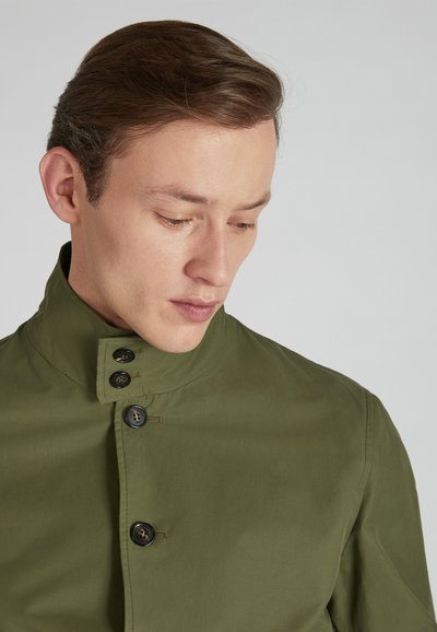 Green, lightweight jacket featuring a high collar, black buttons, and a smooth texture; designed with a modern cut.