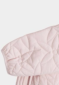 Helle rosa gestepptes Gewebe mit floralem Muster und genähten Details. Verfügt über einen gerafften Ärmelbund und eine glatte Textur.