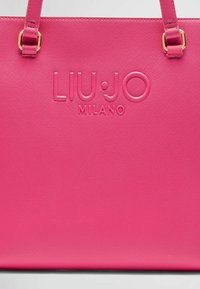 Borsa tote sintetica rosa con logo impresso "LIU•JO MILANO", dotata di due manici superiori e superficie testurizzata. Dettagli in metallo dorato.