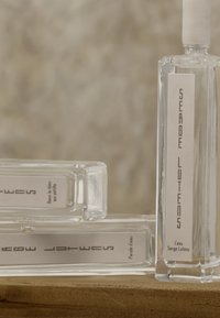 Klare Glasparfümflaschen mit rechteckigen Formen, weiße Etiketten mit klarer Schrift, auf einer Holzoberfläche präsentiert.