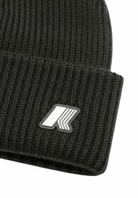 Cappellino nero in maglia con coste verticali, caratterizzato da una toppa con logo bianco con linee angolari. Texture morbida con design a risvolto arrotolato.