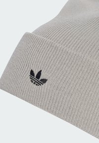 Szürke bordázott kötött sapka puha anyagból, fekete hímzett Adidas logóval a hajtott szegélyén.