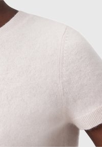 Maglione a maniche corte in morbido cashmere rosa pallido con scollatura rotonda, dotato di dettagli a coste al colletto e alle maniche.