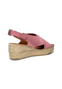 Sandale compensée en suede rose avec un design découpé, talon en jute tressé et bride de cheville réglable. Surface texturée et bout ouvert.