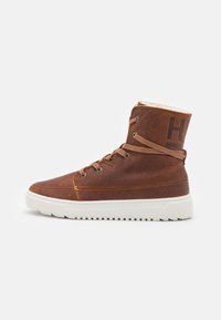 Brown leather high-top sneaker with white rubber sole, flat laces, and orange stitching detail. Features textured upper and logo on heel.
