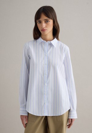 Button-up shirt in light blue and white stripes, collared with a rounded hem, long sleeves, and a smooth cotton texture.