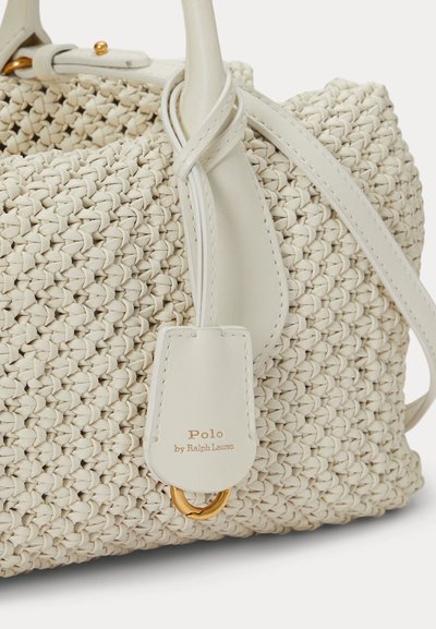 Krém színű fonott táska fehér bőr fogantyúkkal és arany színű karikadísszel, „Polo by Ralph Lauren” logós címkével.