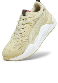 Beżowe sneakersy z mixem gładkich i perforowanych materiałów syntetycznych, z teksturowanymi akcentami i białą gumową podeszwą.