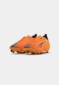 Scarpini da calcio arancioni con un design texturizzato, dettagli neri e materiale sintetico leggero. Progettati per offrire trazione con numerosi tacchetti.