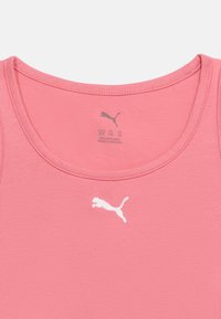Ροζ μπλουζάκι με στρογγυλή λαιμόκοψη και λευκό λογότυπο Puma στο κέντρο κάτω από το γιακά, με ένδειξη μεγέθους και λεπτομέρειες κατασκευής στο εσωτερικό του λαιμού.