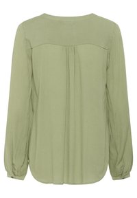 Blouse à manches longues, vue arrière, de couleur vert clair. Fabriquée en tissu texturé avec des plis le long du dos et un ourlet arrondi. Poignets boutonnés.