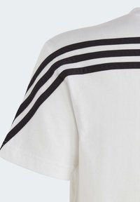 Camiseta blanca con diseño de tres franjas negras en el hombro, de manga corta, hecha de tela de algodón suave, que presenta un cuello redondo clásico.