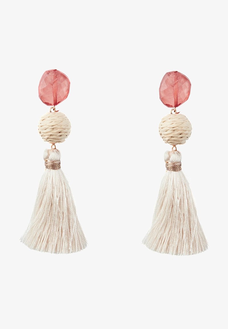 Clous facettés roses avec boule tissée beige et longues boucles d’oreilles à pampilles couleur crème sur fond blanc.