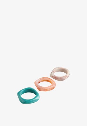 Drei marmorierte, quadratische Harzringe in Türkis, Pfirsich und Hellrosa, diagonal auf weißem Hintergrund angeordnet.