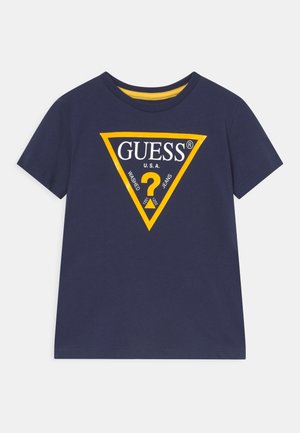 Granatowa koszulka z krótkim rękawem z żółtym obramowaniem trójkątnego logo Guess oraz znakiem zapytania na środku klatki piersiowej.