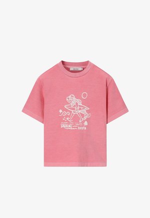 Roze T-shirt met korte mouwen met een witte afbeelding van een lopende vis die een surfplank, zon, ster, schelp en de tekst "SARDINE SIESTA" draagt.