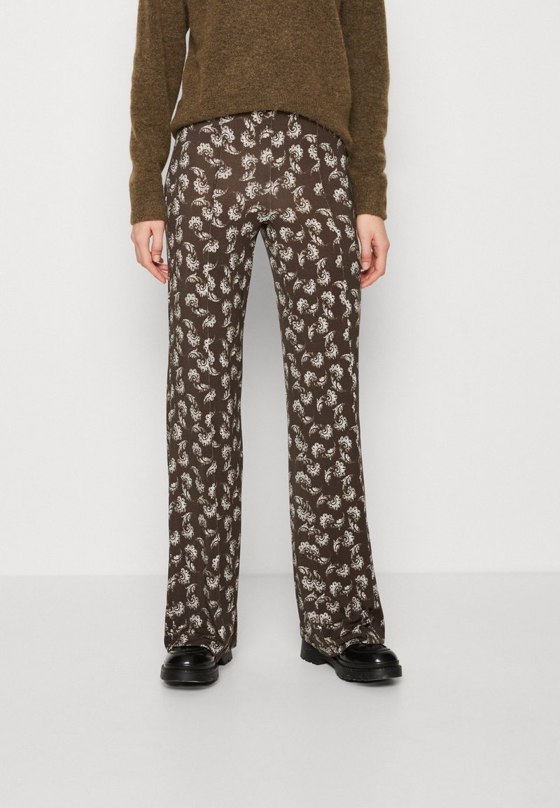 Hnědé vzorované kalhoty s květinovým designem v bílé barvě, vyrobené z lehkého materiálu. Střih je běžný s rozšířeným zakončením nohavic.