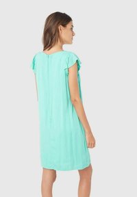 Un vestido de color teal, de manga corta y con un corte relajado, que presenta mangas con volantes y un cierre central trasero. Textura de tela suave y ligera.