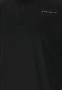 Sort halvdels-zip sportskjorte lavet af glat stof; har et logo-tag "ENDURANCE" placeret på venstre brystområde.