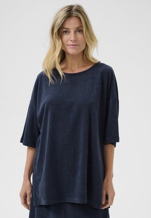 Námořnická modrá oversized tričko vyrobené z měkké froté tkaniny, s kulatým výstřihem a krátkými rukávy, se subtilním vyšívaným logem.