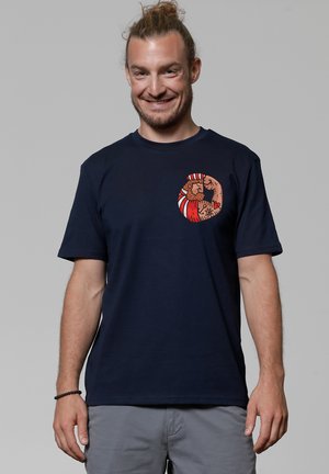 Navyblauwe katoenen T-shirt met een ronde grafische print van twee geïllustreerde figuren in warme kleuren. Korte mouwen en een ontspannen pasvorm ontwerp.