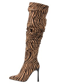 Botas altas de muslo hechas de tela con estampado de cebra, con un diseño arrugado, puntera afilada y tacón de aguja, en tonos de marrón claro y negro.