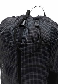 Sac à dos noir avec cordon de serrage, en matériau léger, doté d'un motif en grille, d'un sommet arrondi, d'un cordon ajustable et d'une finition texturée.