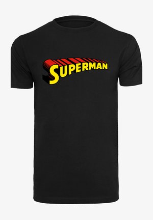 Černé bavlněné tričko s velkým, vícebarevným logem "Superman" v žluté barvě s červenými akcenty a stínovaným písmem přes hruď.