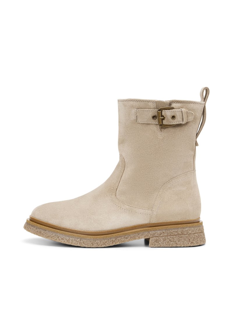 Beige suède enkellaars met een ronde neus, platte rubberen zool en een decoratieve gesp aan de zijkant. Bevat een trek lus aan de achterkant.