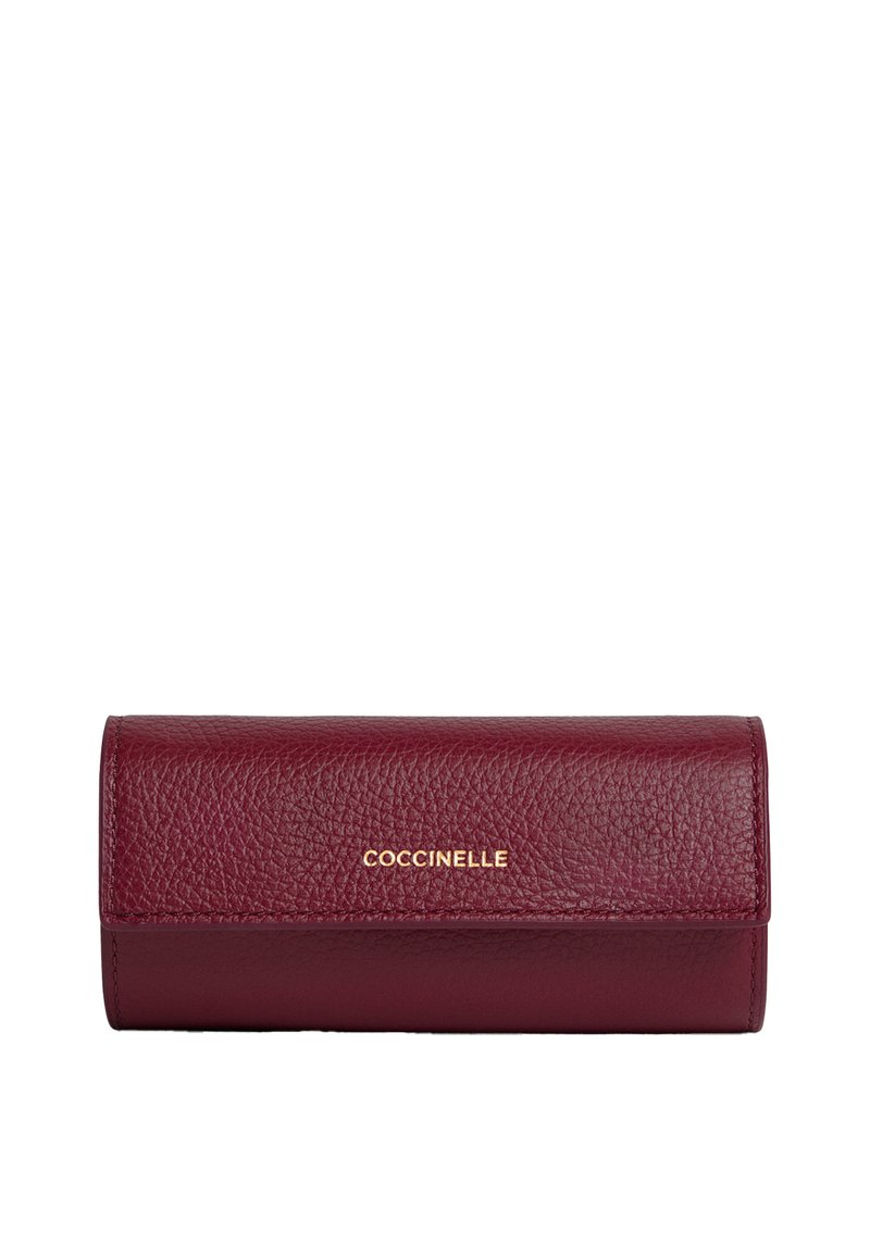 Portafoglio in pelle texturizzata color bordeaux con chiusura a patta, logo dorato "COCCINELLE" centrato sul davanti.