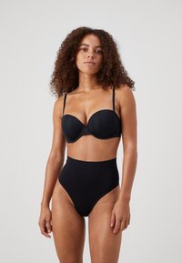 Black lingerie set featuring a padded push-up bra with thin straps and high-waisted briefs. Smooth texture and minimalistic design.