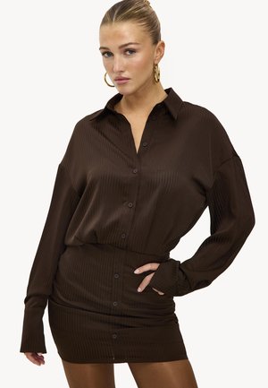 Robe chemise marron à côtes avec un devant boutonné, des manches longues et une silhouette cintrée. Le tissu a une texture lisse et un éclat subtil.