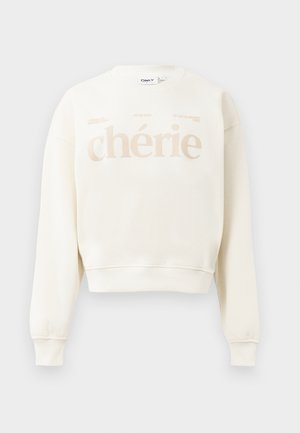 Crème-kleurige langemouwen cropped sweatshirts met geribbelde manchetten en onderrand, met grote beige tekst "chérie" en kleinere tekst erbovenaan aan de voorkant.