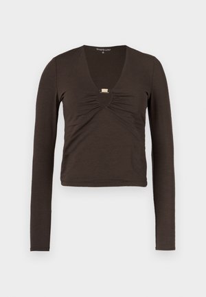 Hnědý top s dlouhými rukávy, hlubokým výstřihem do V, shrnutým materiálem na hrudi a stříbrným detailem pod výstřihem.