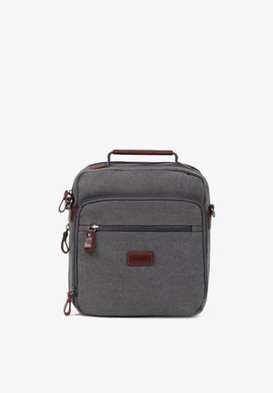 Sac d'épaule en tissu gris avec plusieurs compartiments zippés et une poignée en cuir marron ainsi que des tirettes de fermeture éclair, étiquette frontale indiquant "FAGOLA."