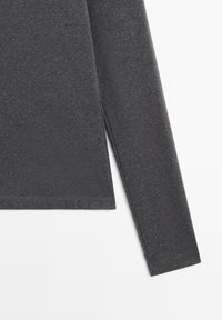 Chemise à manches longues gris foncé avec une texture lisse, présentant des ourlets cousus et une coupe ajustée. Aucun motif ou logo visible.