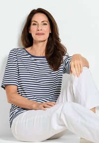 Navy- und weiße gestreifte T-Shirt mit kurzen Ärmeln und Rundhalsausschnitt, kombiniert mit weißen Hosen. Weicher Stoff mit lässiger Passform.