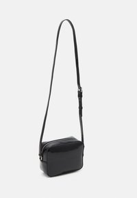 Borsa a tracolla in pelle sintetica nera con forma rettangolare, tracolla regolabile, chiusura con zip e texture liscia. Design minimalista.