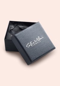 Scatola per gioielli nera con finitura testurizzata, leggermente aperta per rivelare della carta velina nera spiegazzata all'interno. "Sofia Milani Jewels" è stampato sulla parte superiore.
