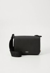 Černá syntetická taška přes rameno s texturovaným povrchem, s logem, obdélníkovým tvarem a nastavitelným popruhem.