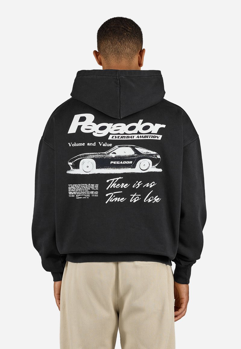 Black hooded sweatshirt with large white text "Pegador" and graphic of a car on the back. Features ribbed cuffs and hem, casual fit.