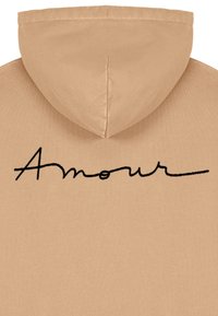 Felpa con cappuccio color cammello dal tocco morbido, caratterizzata da una scritta ricamata in nero "Amour" sul davanti. Design semplice, focalizzato su comfort e stile.