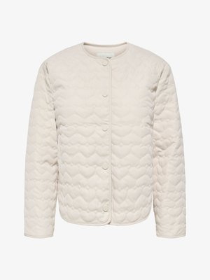 Veste matelassée beige avec surpiqûres en forme de cœur, col rond, manches longues et fermeture à boutons pression devant.