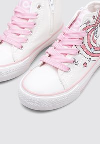 Zapatillas altas de lona blancas con cordones rosas, acentos rosas en la suela de goma y un diseño gráfico de unicornio que presenta estrellas y remolinos.