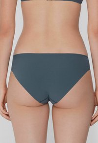 Tmavě šedé bikinové dno vyrobené z hladkého materiálu, s minimálním pokrytím a jednoduchým designem a čistými švy.