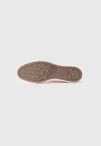 Rubber shoe sole with a patterned grip. Tread features geometric designs, transitioning to a pink upper edge. Smooth and contrasting texture.
