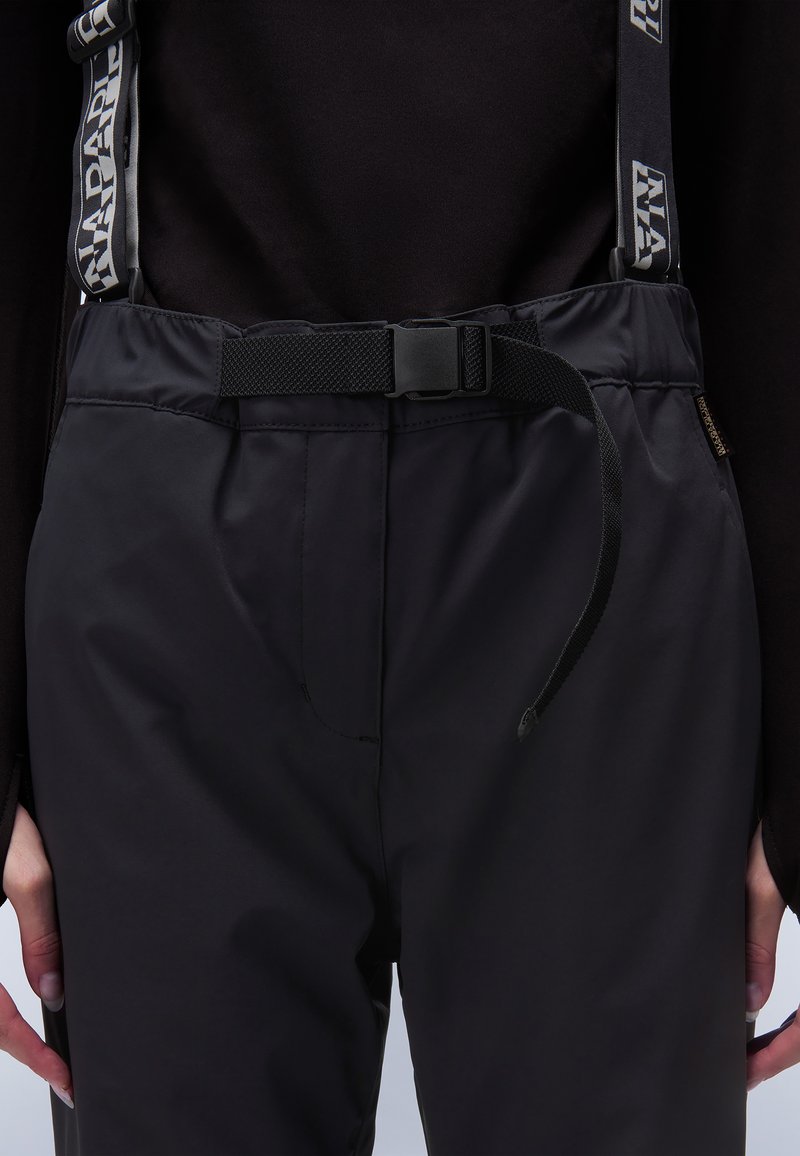 Pantalones impermeables negros con tirantes de malla ajustables y cinturón. Presenta un diseño aerodinámico y bolsillos prácticos. Textura suave y duradera.